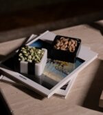 Masada iki küçük siyah beyaz çerezlikte fındıklar ve bir kitap bulunuyor.