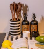 Modern çizgili mermer servis tepsisinde bir kitap, bir bıçak ve bir şişe yemeklik yağın bulunduğu mutfak tezgahı.